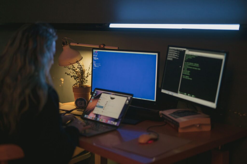 Analyste en cybersécurité surveillant des écrans multiples dans un centre d'opérations de sécurité moderne